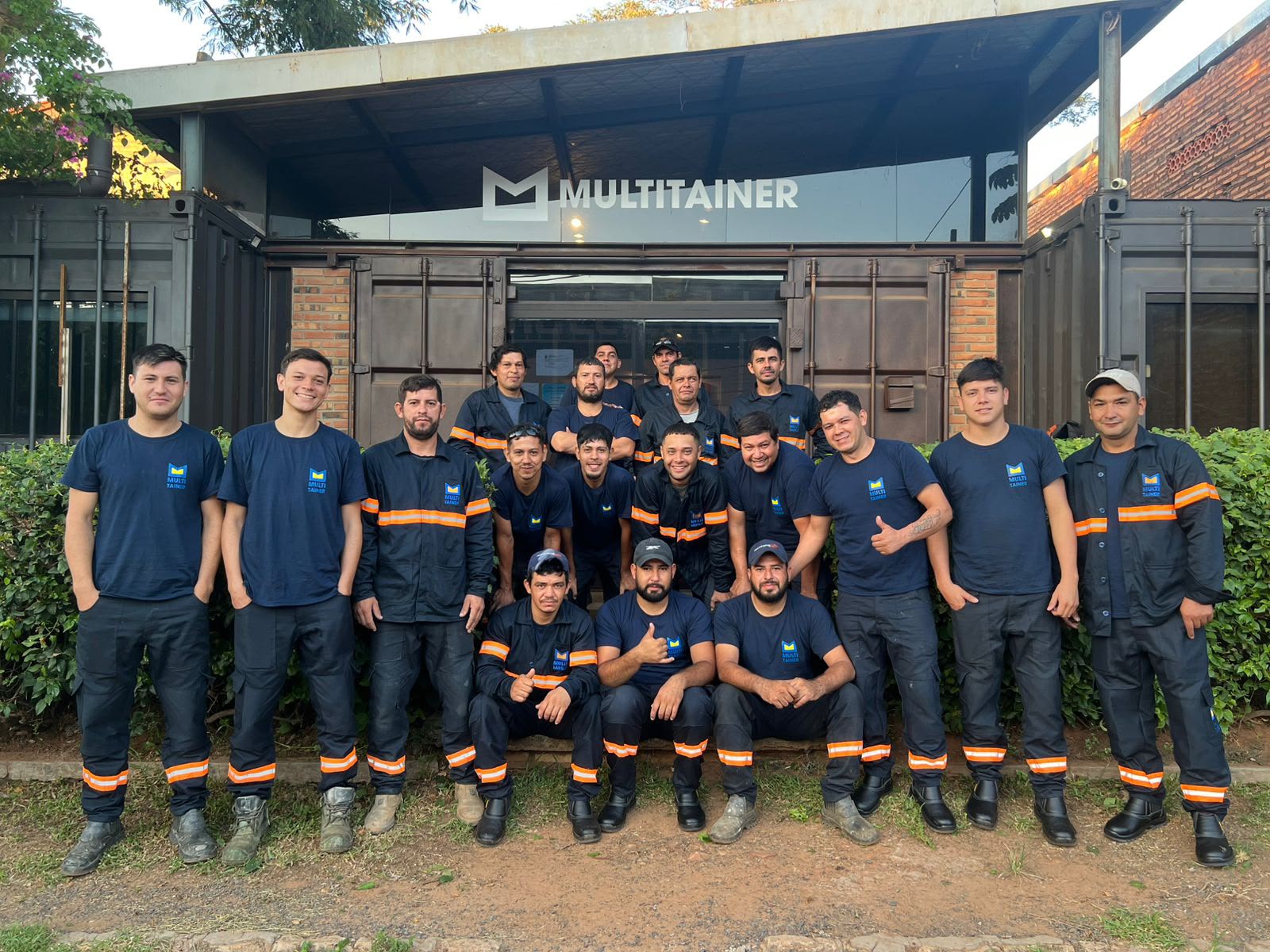 El equipo del taller de Mariano Roque Alonso frente al portón con la marca Multitainer